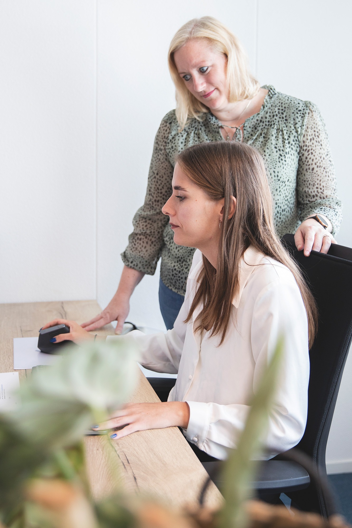 Medewerker van Marker Media ontvangt begeleiding van een collega tijdens het creatieve ontwerpproces op kantoor.