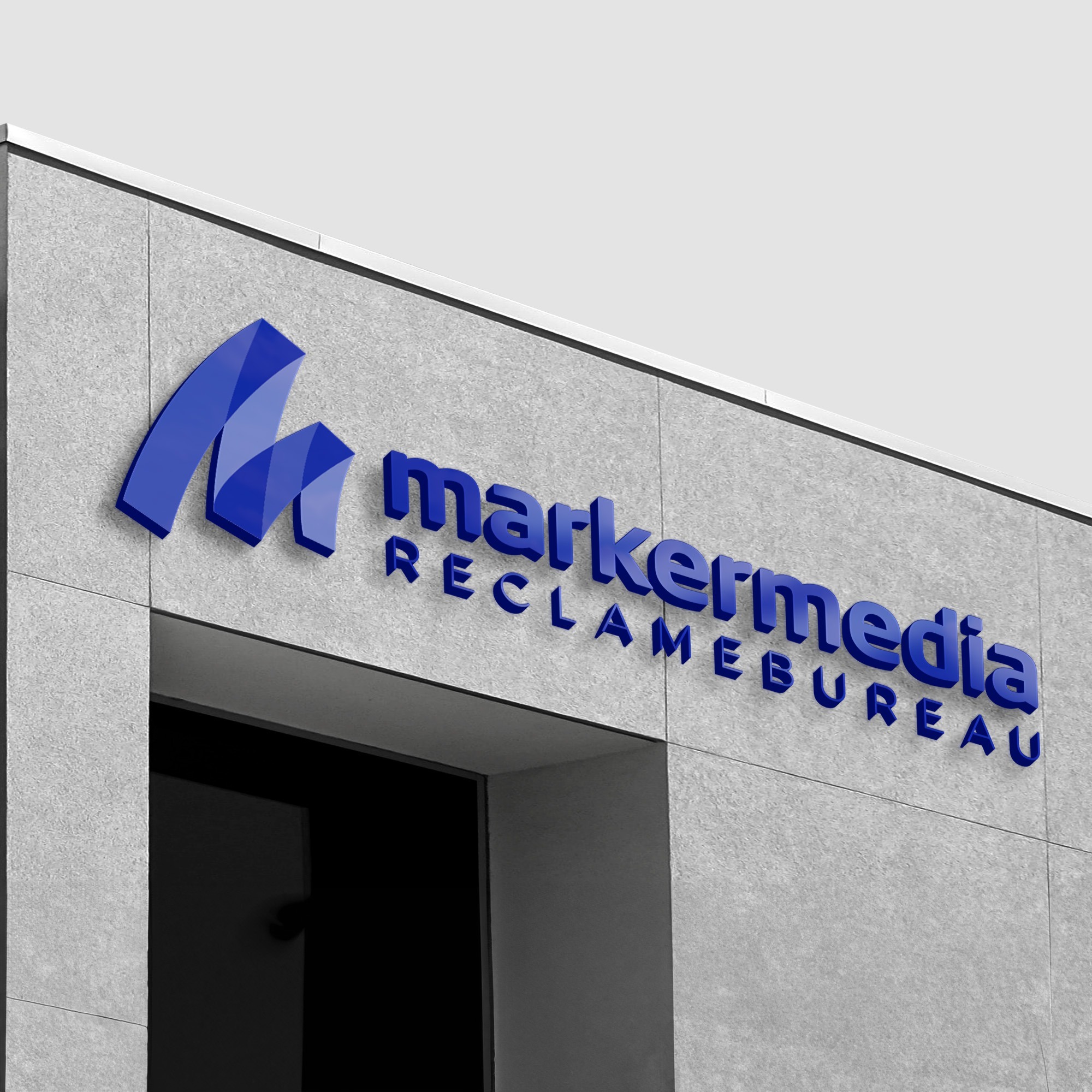 Een close-up afbeelding van de gevelreclame voor Marker Media, weergegeven op een modern gebouw. Het logo van Marker Media in een opvallende blauwe kleur is prominent zichtbaar, met daaronder de tekst 'marker media reclamebureau' in een strakke lettertype. De reclame is elegant geplaatst op een grijze muur, waardoor het logo en de tekst goed tot hun recht komen.