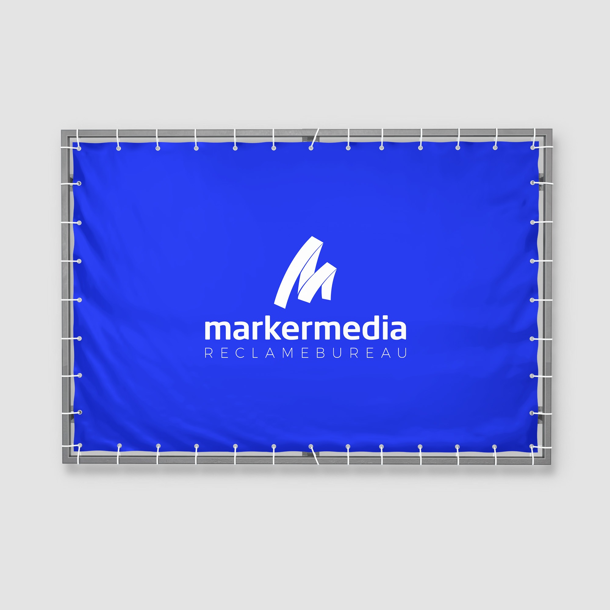 Een afbeelding van een spandoek voor Marker Media, bevestigd aan een stevig frame. Het spandoek is in een levendige blauwe kleur met het logo en de naam van het reclamebureau in grote, witte letters. De randen van het spandoek zijn stevig vastgemaakt met touwen, waardoor het een professionele en aantrekkelijke uitstraling heeft.